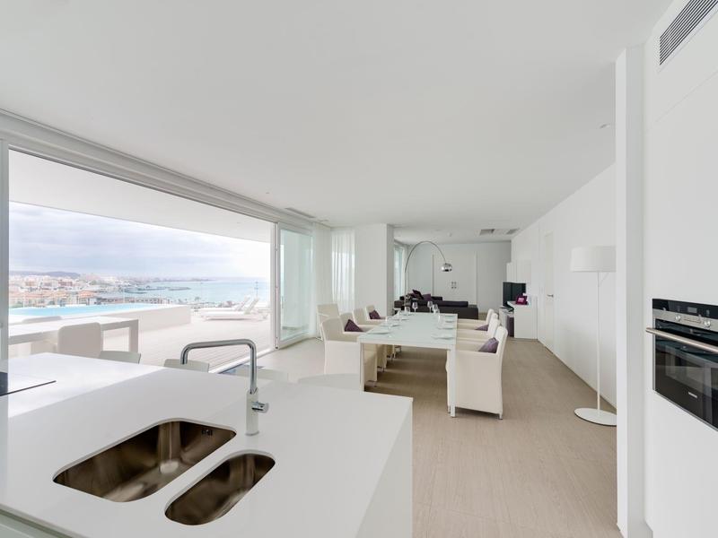 Espace de vie moderne et lumineux avec cuisine ouverte et grande fenêtre donnant sur la mer