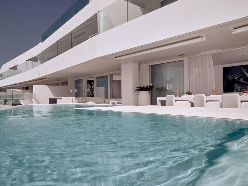 Bâtiment d’hôtel moderne avec balcons et piscine au premier plan