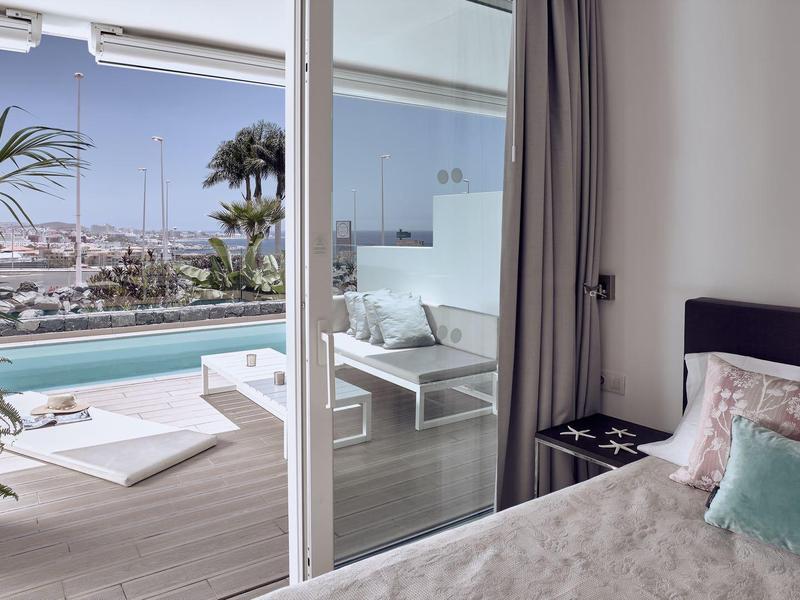 Chambre avec vue sur terrasse, piscine et marina en plein jour