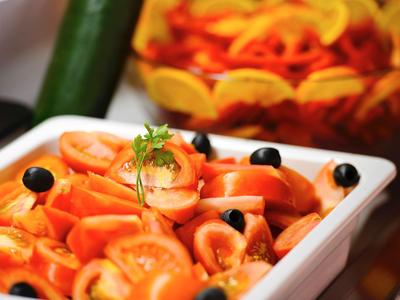 Großer blauer Pool mit mehreren Liegen und modernen Hotelgebäuden im Hintergrund bei Tageslicht.