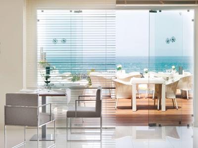 Sala da pranzo moderna con vista mare e parete di vetro trasparente