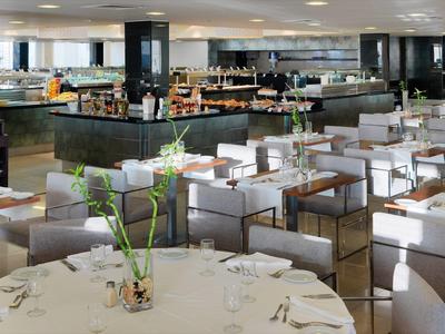 Nowoczesna restauracja z eleganckimi stołami, krzesłami i stylową dekoracją stołu.