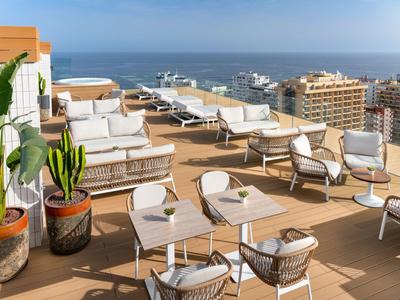 Moderne Dachterrasse mit Sitzgruppen und Meerblick in einem Hotel.