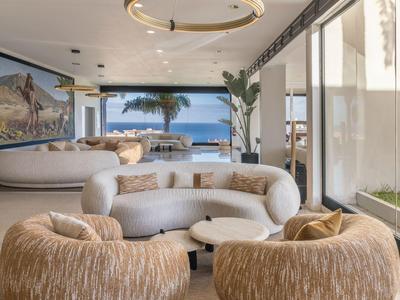 Moderner Hotel-Loungebereich mit Designer-Sesseln, Glasfront und Meerblick.