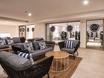 Przytulna przestrzeń lounge w hotelu z nowoczesnymi tapicerowanymi meblami i dekoracyjnymi poduszkami.