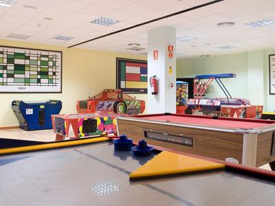 Interior of a game room with pool table, air hockey, and various games.