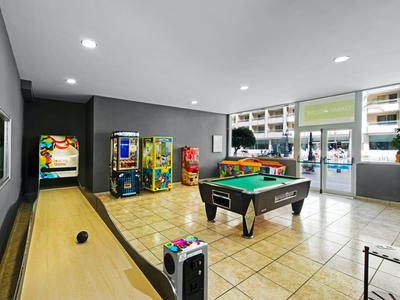 Pokój rekreacyjny z bilardem, grami arcade i zestawem do kręgli w hotelu.