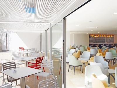 Modern dining area with colorful chairs and tables, separated indoors and outdoors by glass.
