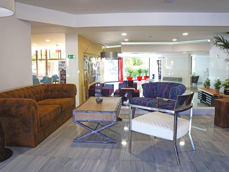 Modern hotel lobby with various seating options and decorative plants.