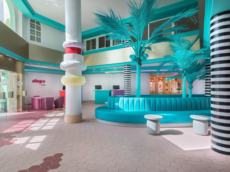 Jasne lobby z turkusowymi kanapami i kolorową dekoracją w hotelu.