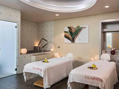 Spakamer met twee massagetafels, zachte verlichting en moderne inrichting voor ontspanning.