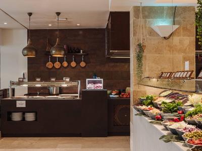 Moderne buffetopstelling met hanglampen, pannendisplay en diverse verse salades en gerechten.