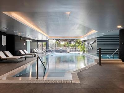 Overdekt zwembadd met ligstoelen en warme verlichting, voor een ontspannen sfeer.