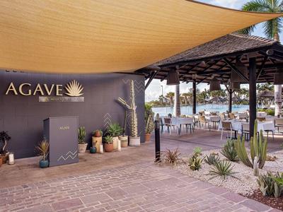 Außerhalb des Agave Restaurants mit Sitzbereich unter einer überdachten Terrasse und Kakteengarten.