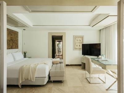 Lichte, moderne hotelkamer met een groot bed, flatscreen-tv, bureau en elegante inrichting.