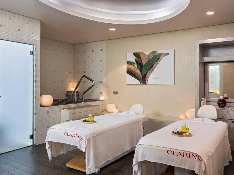 Spakamer met twee massagetafels, zachte verlichting en moderne inrichting voor ontspanning.