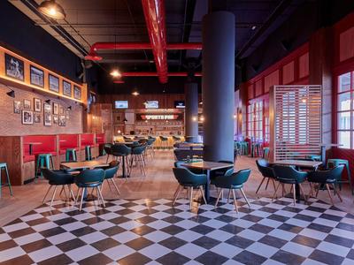 Modern hotel restaurant with checkered floor, chairs, and large windows.