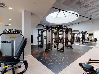 Bright, modern gym with extensive equipment and large window in the hotel.