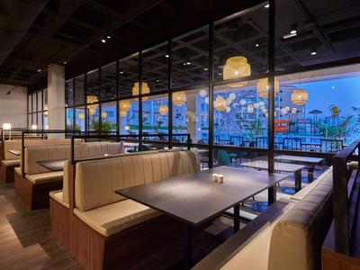 Modern restaurant with cozy seating and large windows offering a view.