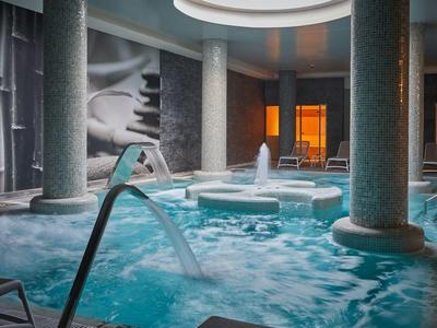 Indoor hotel area with Jacuzzi and elegant columns in a relaxed atmosphere.