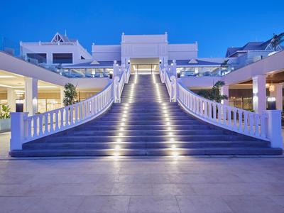 Velké osvětlené schodiště před moderní hotelovou budovou za soumraku.