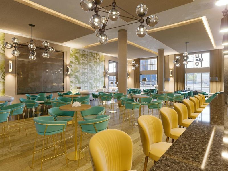 Moderní hotelová louž s žlutými a zelenými židlemi a stylovým osvětlením.