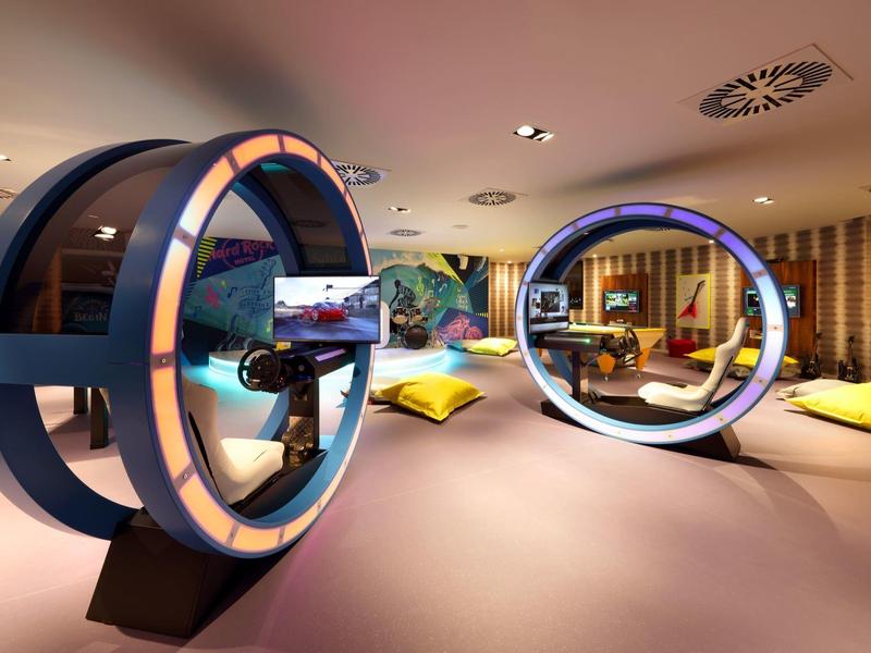 Futuristische hotellobby met ronde zithoeken en kleurrijke kussens op de vloer.