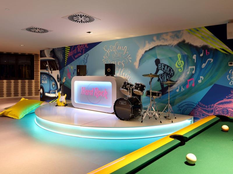 Moderne speelkamer met biljarttafel, drums en kleurrijke street art muurschildering.