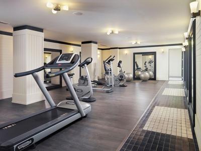 Salle de sport moderne avec tapis de course et équipements d'exercice dans un hôtel.