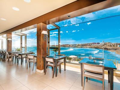 Nowoczesna restauracja z panoramicznymi oknami z widokiem na wybrzeże i ocean.