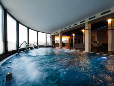 Basen kryty z jacuzzi i dużymi oknami z widokiem w hotelu.