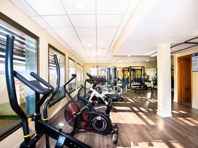 Salle de sport moderne avec vélos d'appartement et sol en bois clair