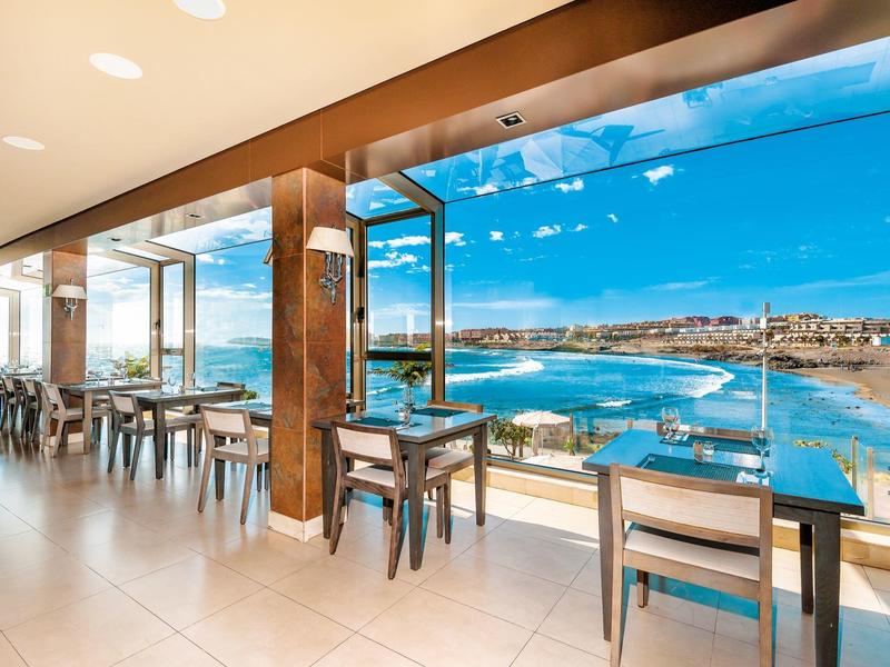 Nowoczesna restauracja z panoramicznymi oknami z widokiem na wybrzeże i ocean.