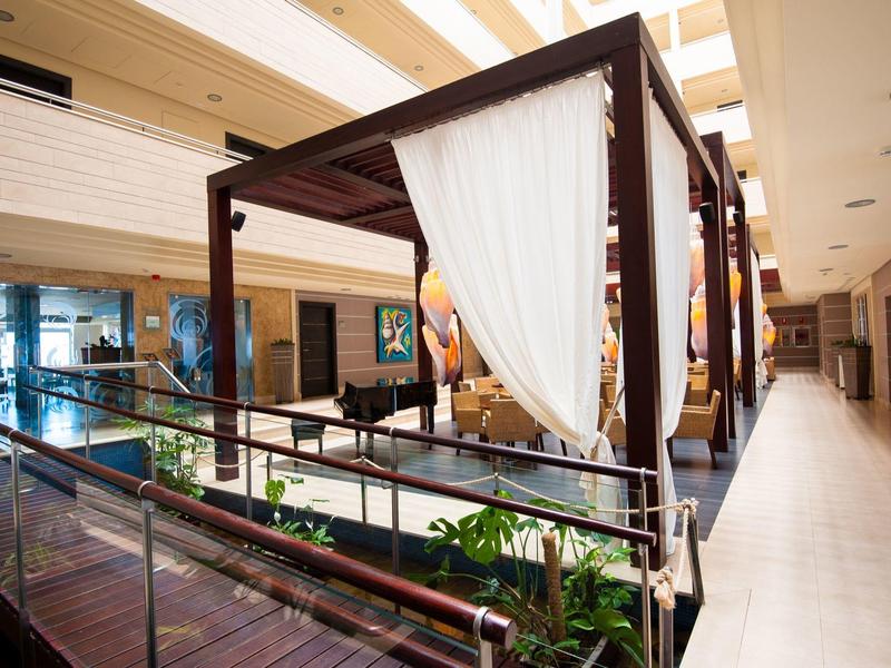 Wnętrze nowoczesnego hotelu z szklanymi balustradami i miejscem z białymi zasłonami