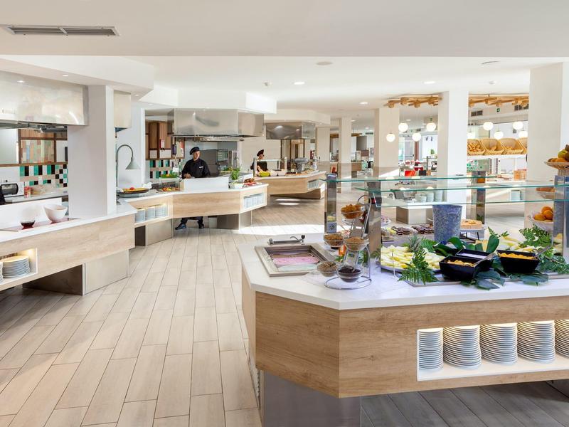 Ristorante a buffet moderno e luminoso con vari piatti e spuntini sui banchi.