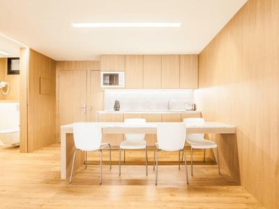 Moderner heller Konferenzraum mit Holzvertäfelung, großem Tisch und weißen Stühlen.