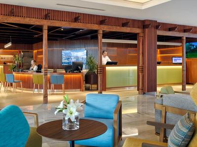 Moderne Hotellobby mit Sitzbereich, Holzakzenten und einer einladenden Rezeption.