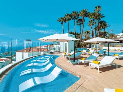 Nowoczesny basen z leżakami i parasolami w słonecznym hotelowym otoczeniu