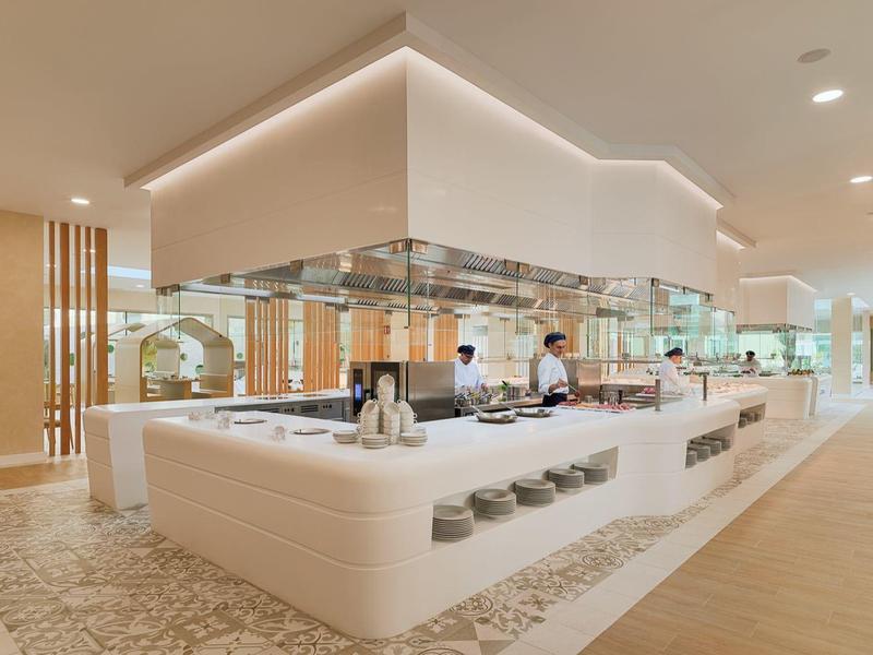 Modern open hotelrestaurant met een lichte inrichting en open keuken.