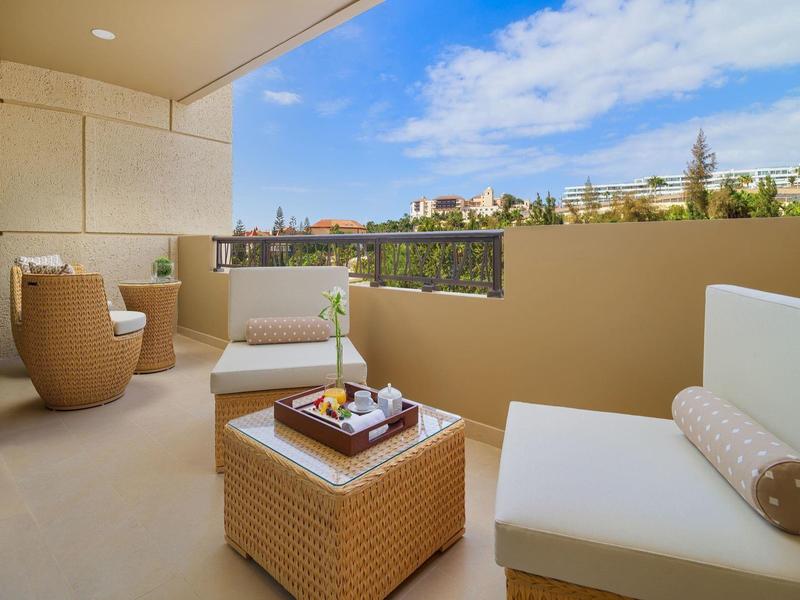 Knusse balkon met zitmeubilair en uitzicht op een rustige woonwijk