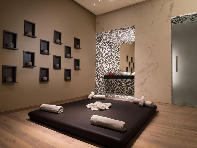 Rustige spa-ruimte met vloermat, handdoeken, decoratie en gedimd licht.