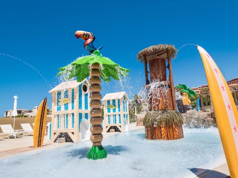 Kleurrijke waterspeeltuin met surfplank en schuim in zonnig resort