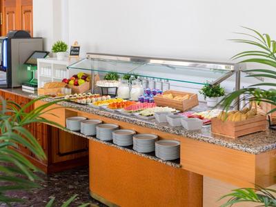 Buffet met vers fruit, sappen en schalen in een lichte ontbijtruimte.