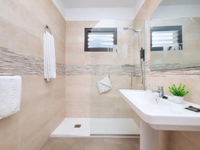 Moderne badkamer met inloopdouche, grote spiegel en wastafel.