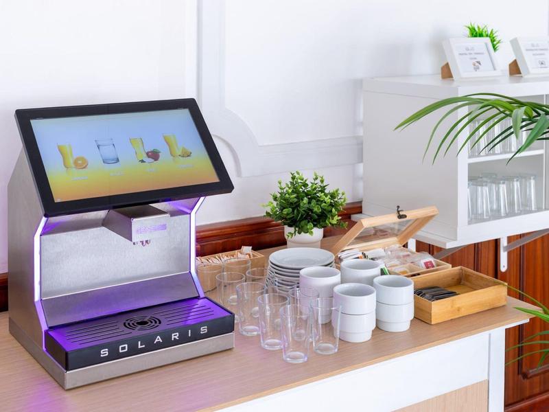 Een drankensensor en glaswerk op een toonbank in een lichte kamer.