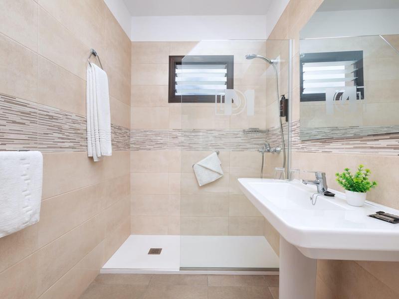 Moderne badkamer met inloopdouche, grote spiegel en wastafel.