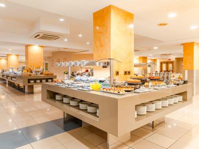 Ristorante a buffet luminoso e moderno con ampia scelta di cibo e illuminazione calda.