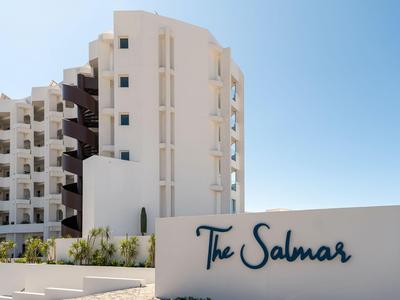 Moderno edificio alberghiero bianco sotto un cielo sereno con il nome The Salmar.