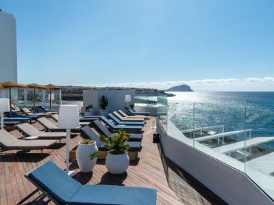 Terrazza solarium con lettini e vista mare in una giornata di sole.