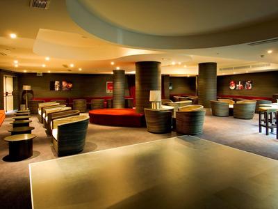 Przestronny hotelowy salon z nowoczesnymi siedzeniami i ciepłym oświetleniem.